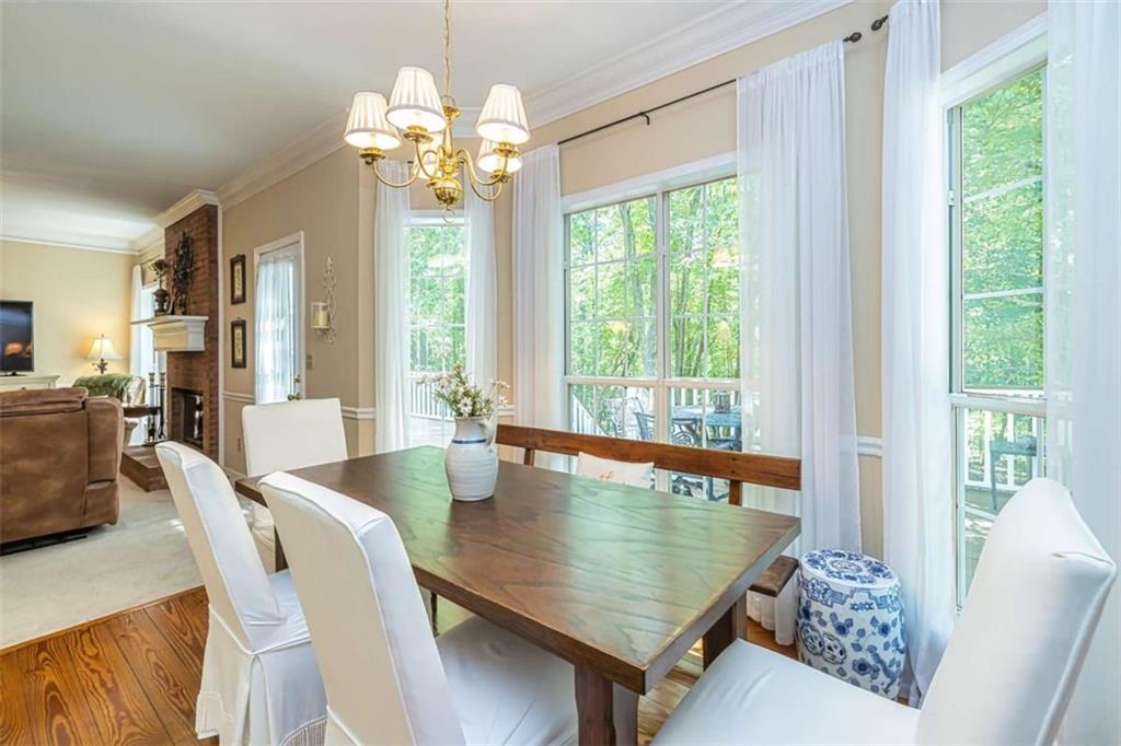 6009 Big A Road Douglasville, GA 30135 - Photo 15 of 50 a dining room with wooden floor a chandelier a wooden table and chairs
