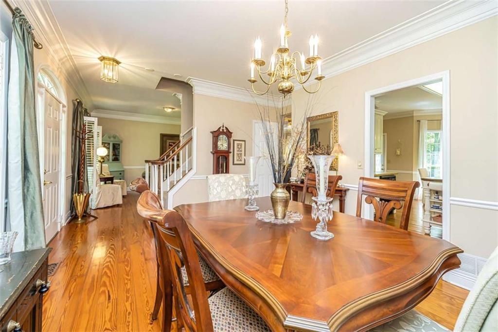 6009 Big A Road Douglasville, GA 30135 - Photo 9 of 50 a dining room with wooden floor a chandelier a wooden table and chairs