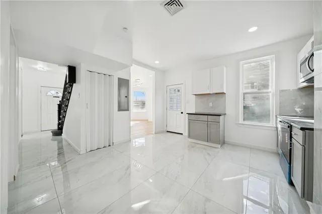 a kitchen with white cabinets and stainless steel appliances