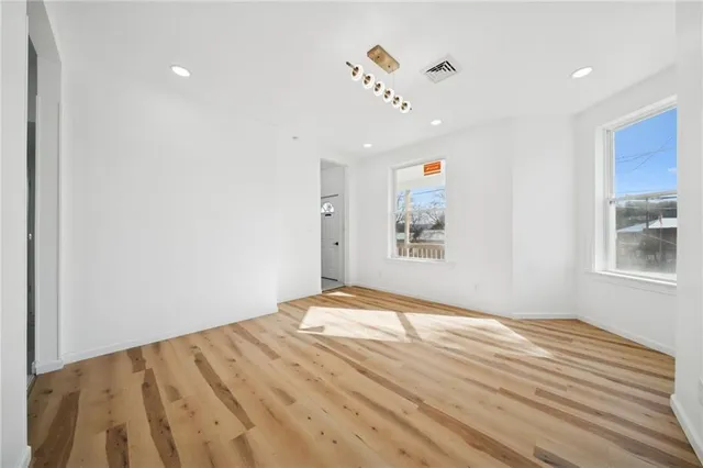 a view of empty room with wooden floor