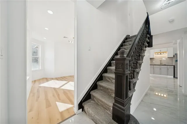 a view of hallway with stairs and wooden floor
