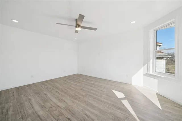 a view of empty room with wooden floor and window