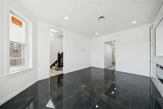 a view of an empty room with wooden floor and a cabinet
