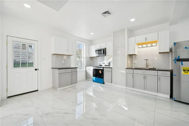 a kitchen with white cabinets and white appliances