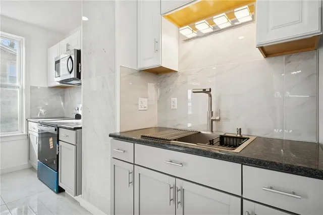 a kitchen with stainless steel appliances granite countertop a sink stove and cabinets