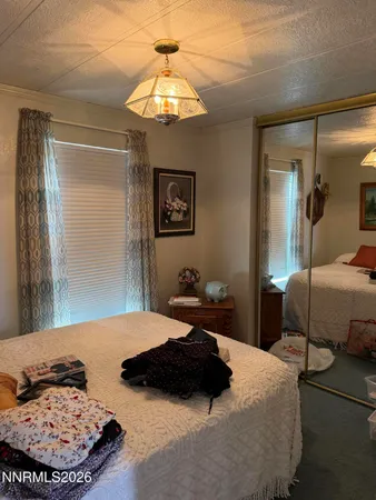 a bedroom with a bed a lamp and a large mirror