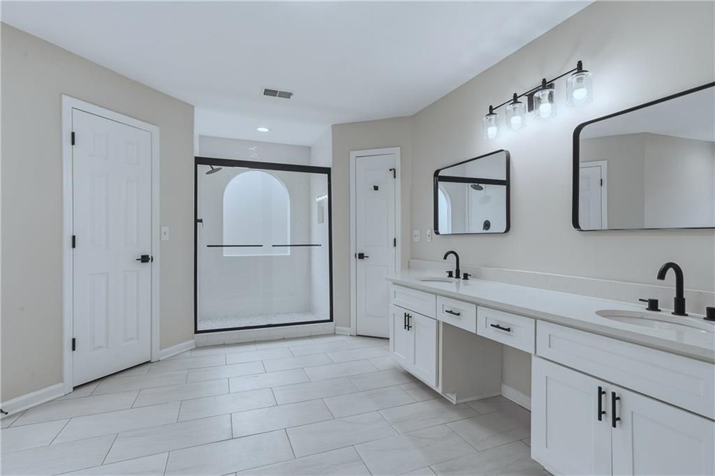 2800 Lakewind Court Alpharetta, GA 30005 - Photo 16 of 26 a bathroom with a double vanity sink a and a mirror