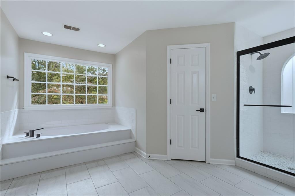 2800 Lakewind Court Alpharetta, GA 30005 - Photo 17 of 26 a bathroom with a bathtub and a shower