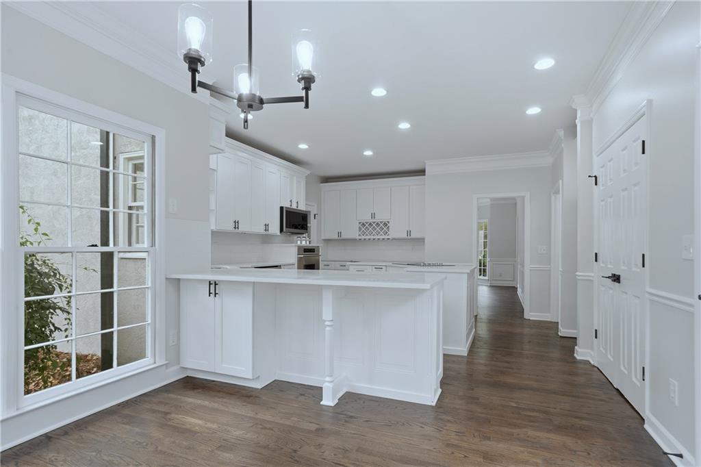 2800 Lakewind Court Alpharetta, GA 30005 - Photo 8 of 26 a large kitchen with stainless steel appliances kitchen island a large counter top and a chandelier