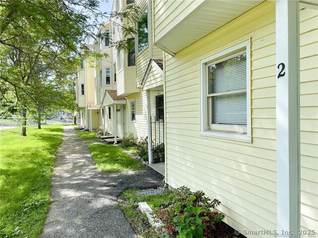 77 Marion Avenue, Unit 2 Torrington, CT 06790 - Photo 33 of 35 a view of a brick house with a yard and plants