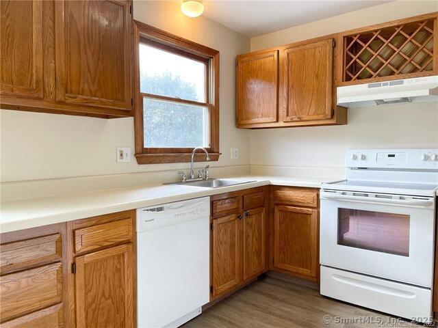 77 Marion Avenue, Unit 2 Torrington, CT 06790 - Photo 5 of 35 a kitchen with stainless steel appliances granite countertop a sink and cabinets with wooden floor