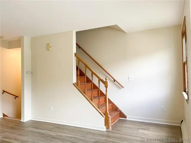 a view of entryway and hall with wooden floor