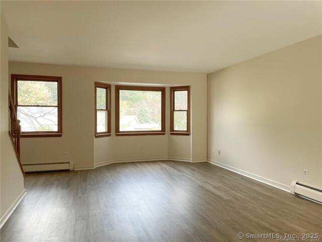 77 Marion Avenue, Unit 2 Torrington, CT 06790 - Photo 7 of 35 an empty room with wooden floor and windows