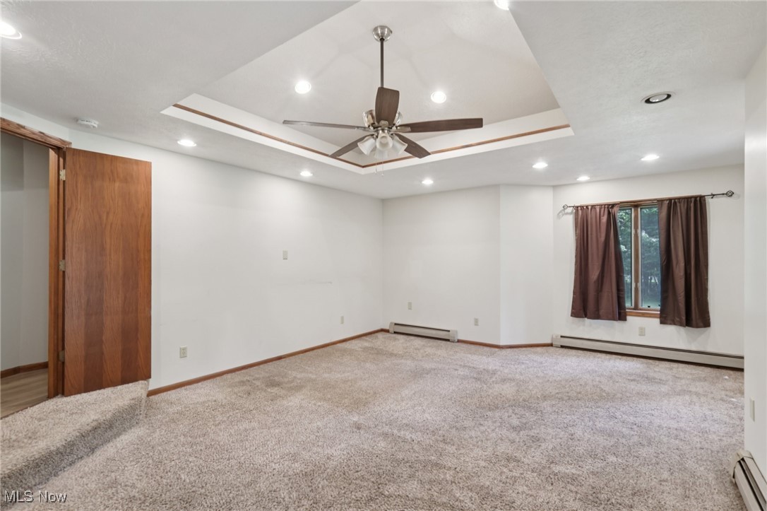 5643 Chapin Road Madison, OH 44057 - Photo 28 of 50 Unfurnished room featuring a baseboard heating unit, a tray ceiling, carpet, and recessed lighting