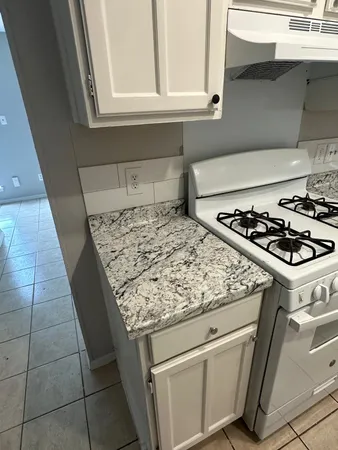 a white stove top oven sitting inside of a kitchen