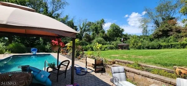 a swimming pool with lawn chairs and potted plants
