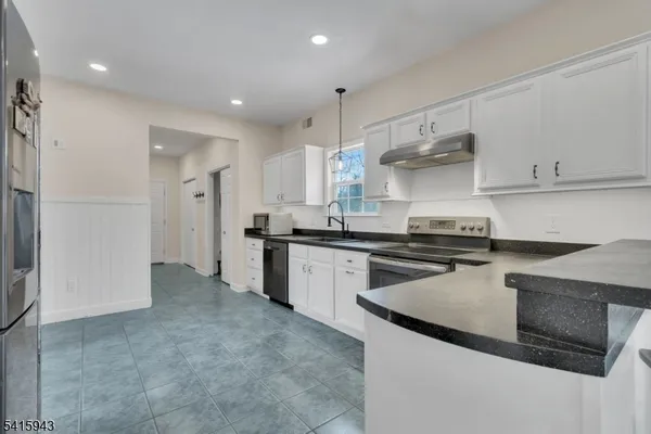a kitchen with stainless steel appliances granite countertop a sink and a stove
