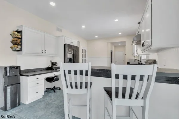 a kitchen with refrigerator and cabinets