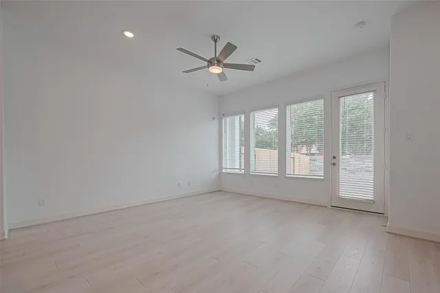 an empty room with a window and a fan