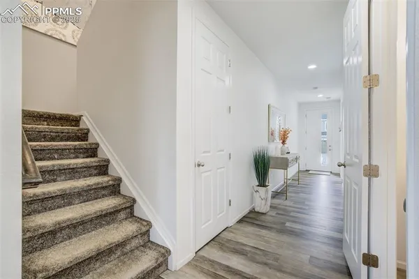 a view of a hallway with wooden floor and stairs