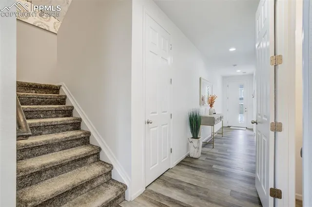 a view of a hallway with wooden floor and stairs