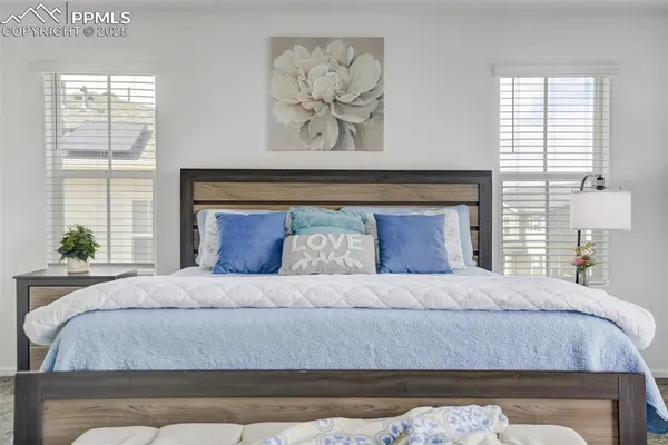 a bedroom with a bed and a painting on the wall