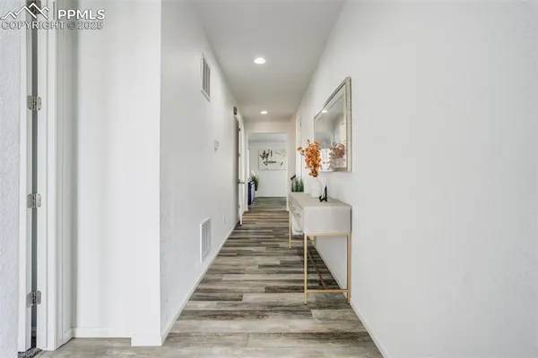 a view of a hallway with wooden floor and entryway