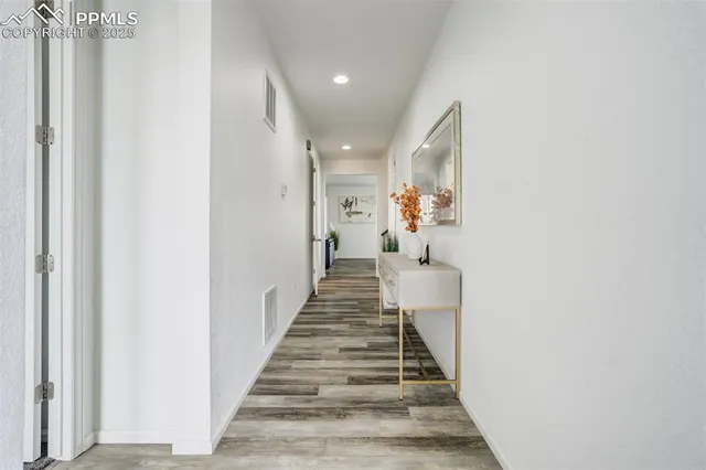 a view of a hallway with wooden floor and entryway