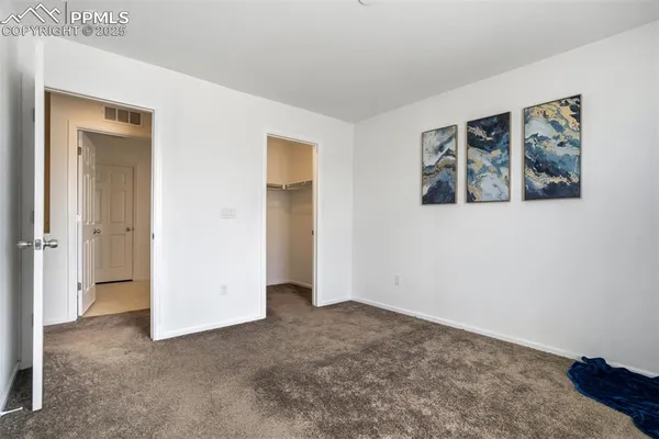 a view of an empty room with window and closet