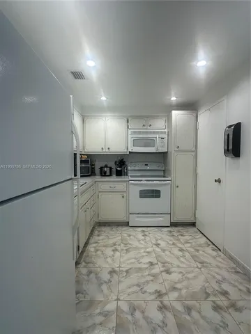 a kitchen with stainless steel appliances a refrigerator and a stove top oven