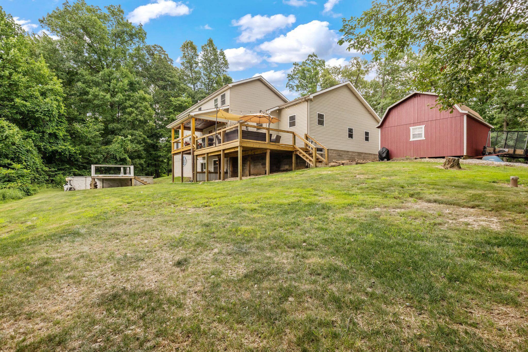 10446 Rich Hollow Road Southwest Lancaster, OH 43130 - Photo 74 of 83 Expansive sloped lawn with a two-story residence, multi-level wooden deck, and an additional red barn structure