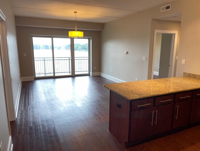 728 North Diamond Lake Road, Unit 205 Mundelein, IL 60060 - Photo 8 of 19 a kitchen with a wooden cabinets and a wooden floor