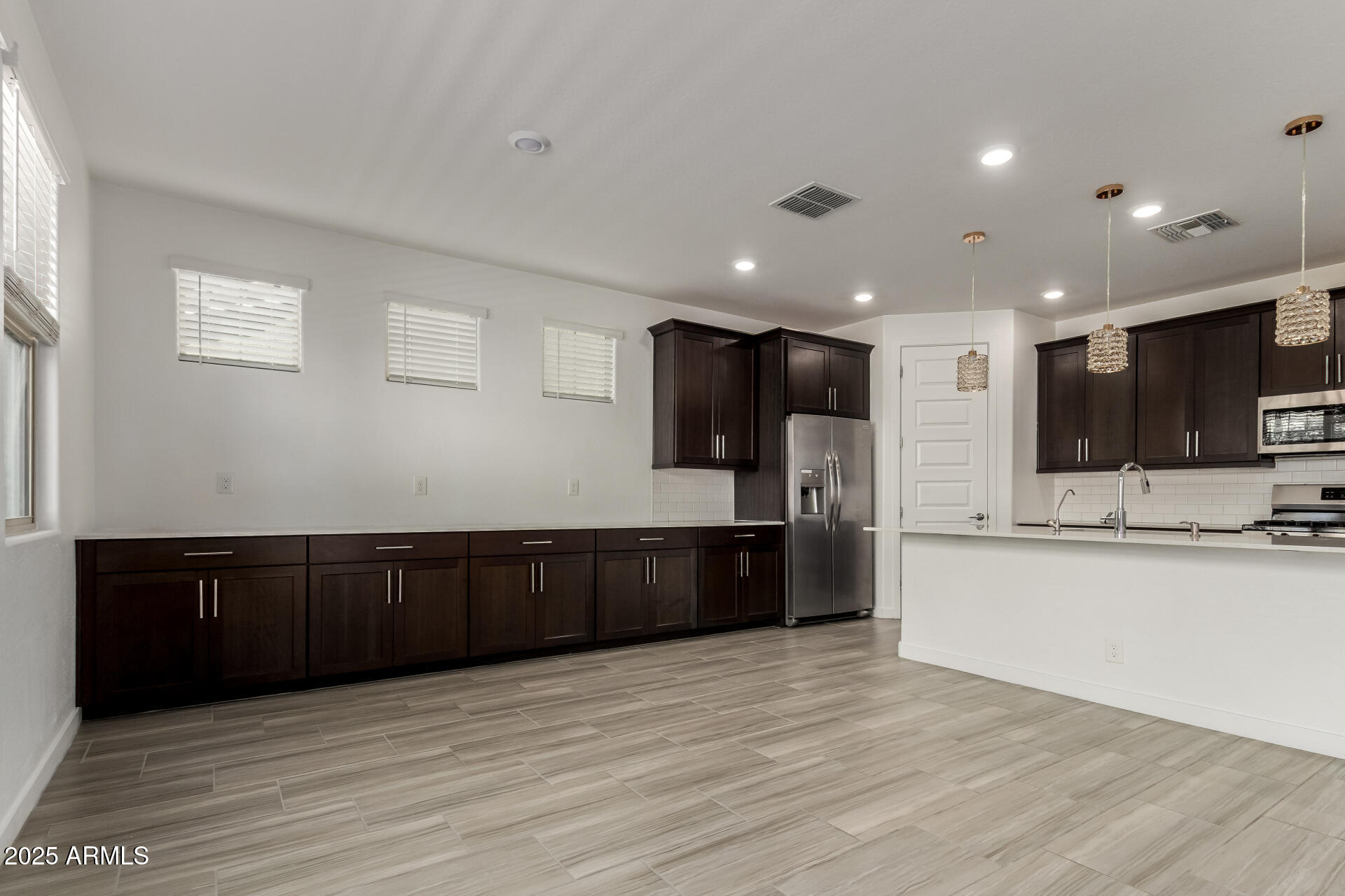 1156 East Weatherby Way Chandler, AZ 85286 - Photo 11 of 47 a large kitchen with stainless steel appliances granite countertop a large counter top and wooden floors