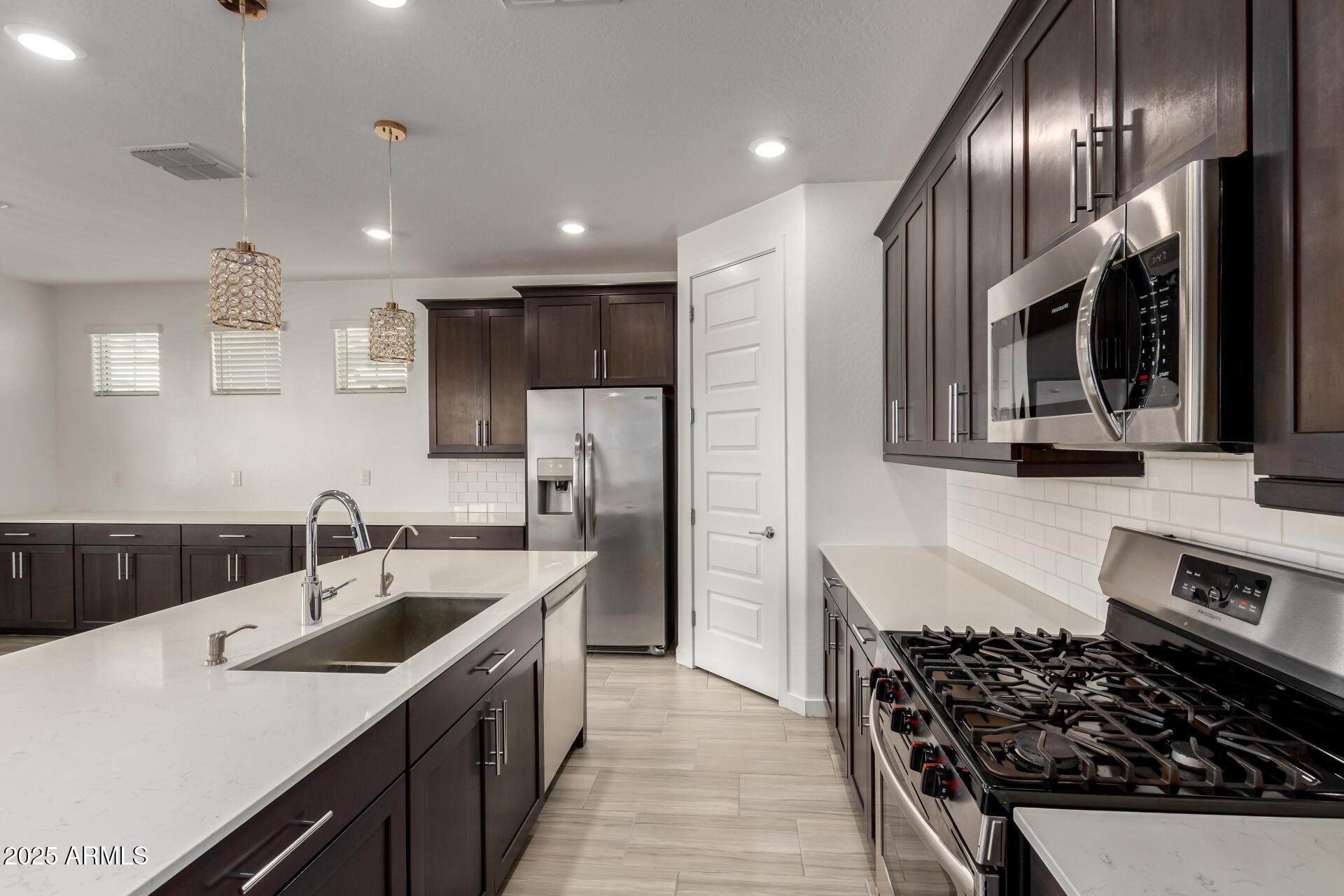 1156 East Weatherby Way Chandler, AZ 85286 - Photo 17 of 47 a kitchen with stainless steel appliances sink stove microwave and cabinets