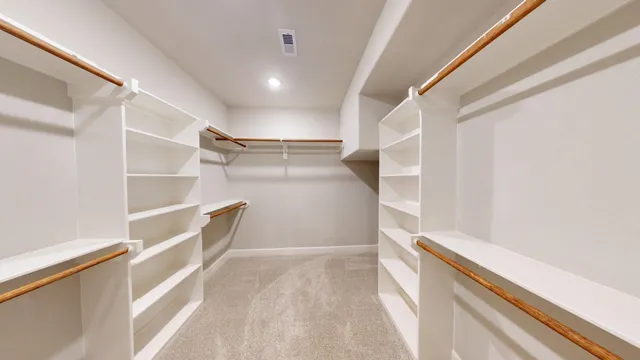 a view of walk in closet with empty racks