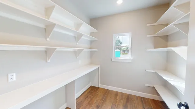 a view of walk in closet with wooden floor