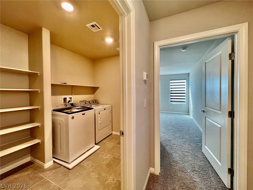 7845 Morganite Avenue Las Vegas, NV 89113 - Photo 14 of 21 A dedicated laundry room with convenient built-in shelving, tile flooring, and modern appliances.