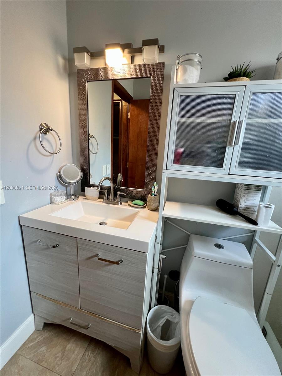 3610 Southwest 113th Place Miami, FL 33165 - Photo 12 of 49 a bathroom with a toilet sink and mirror