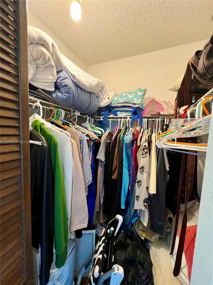 3610 Southwest 113th Place Miami, FL 33165 - Photo 32 of 49 a view of walk in closet with clothes and shoes