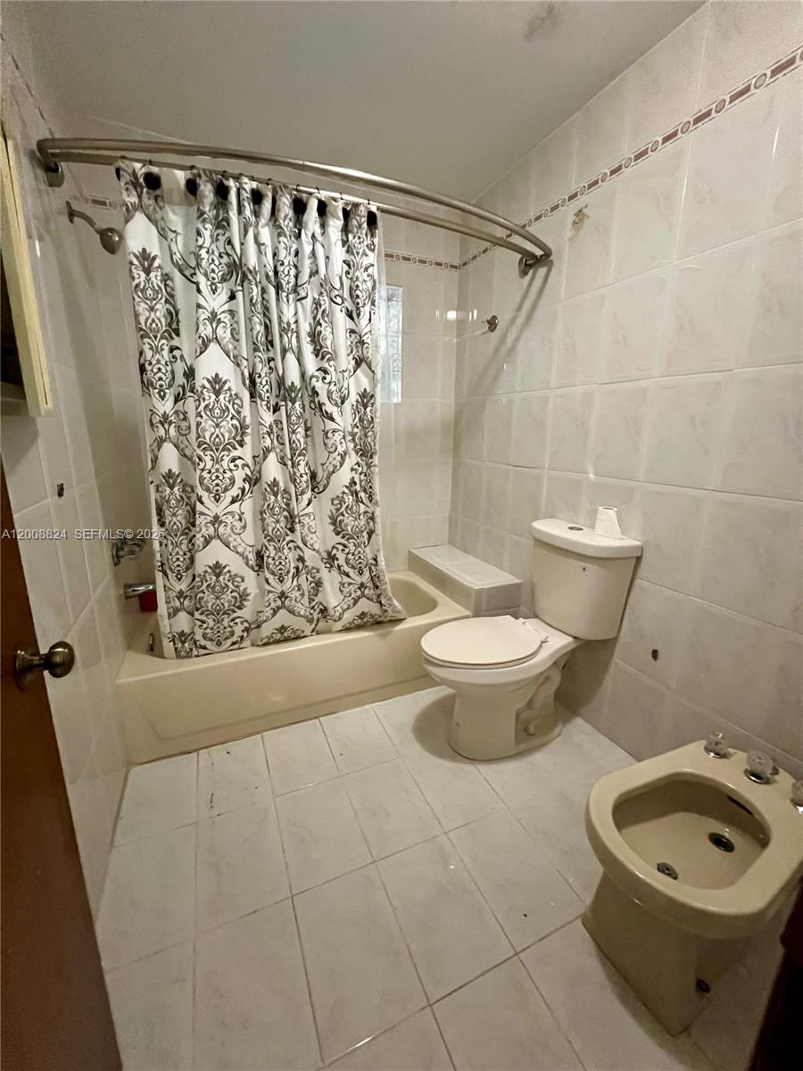 3610 Southwest 113th Place Miami, FL 33165 - Photo 39 of 49 a bathroom with a toilet and a shower curtain
