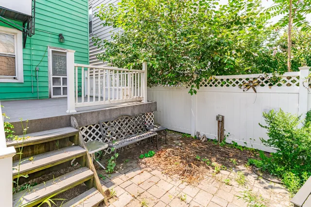 a view of wooden bench in backyard of house