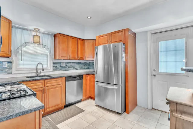 a kitchen with stainless steel appliances granite countertop a stove sink microwave and cabinets