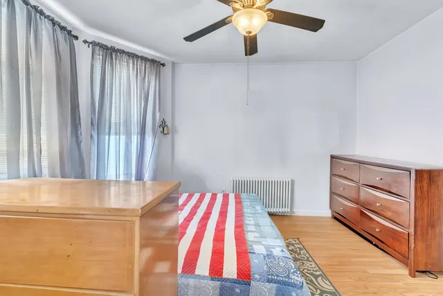 a view of a bedroom with wooden floor and cabinet