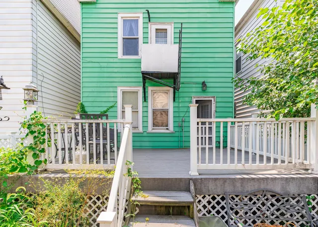 a view of a house with a small yard and wooden fence