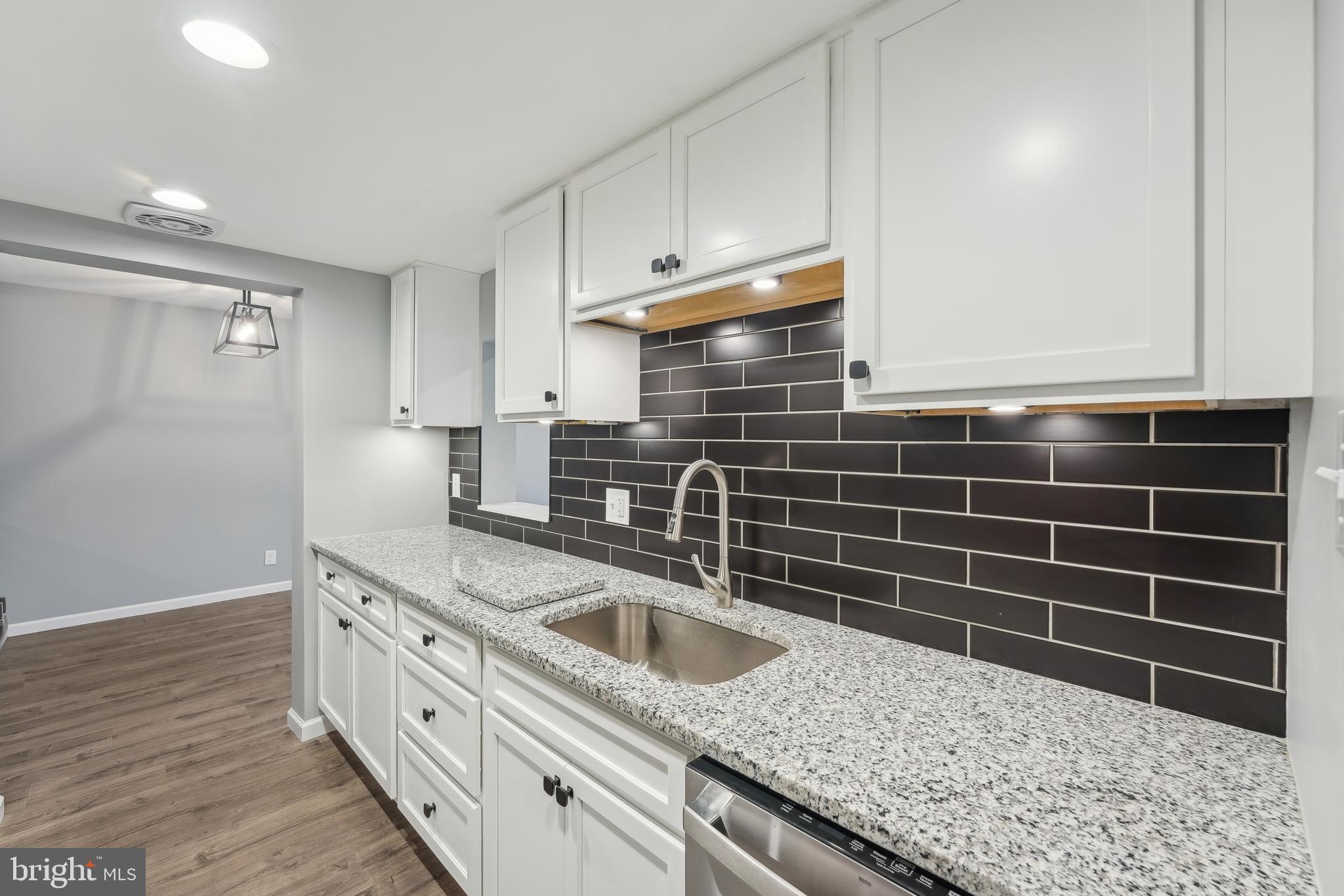 203 Drummers Lane, Unit 203 Wayne, PA 19087 - Photo 12 of 40 a kitchen with granite countertop a sink a stove and cabinets