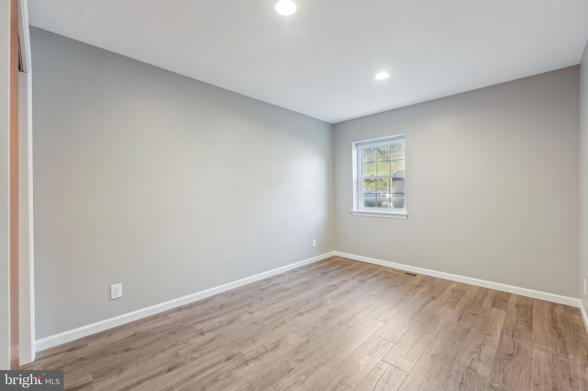 203 Drummers Lane, Unit 203 Wayne, PA 19087 - Photo 16 of 40 an empty room with wooden floor and windows