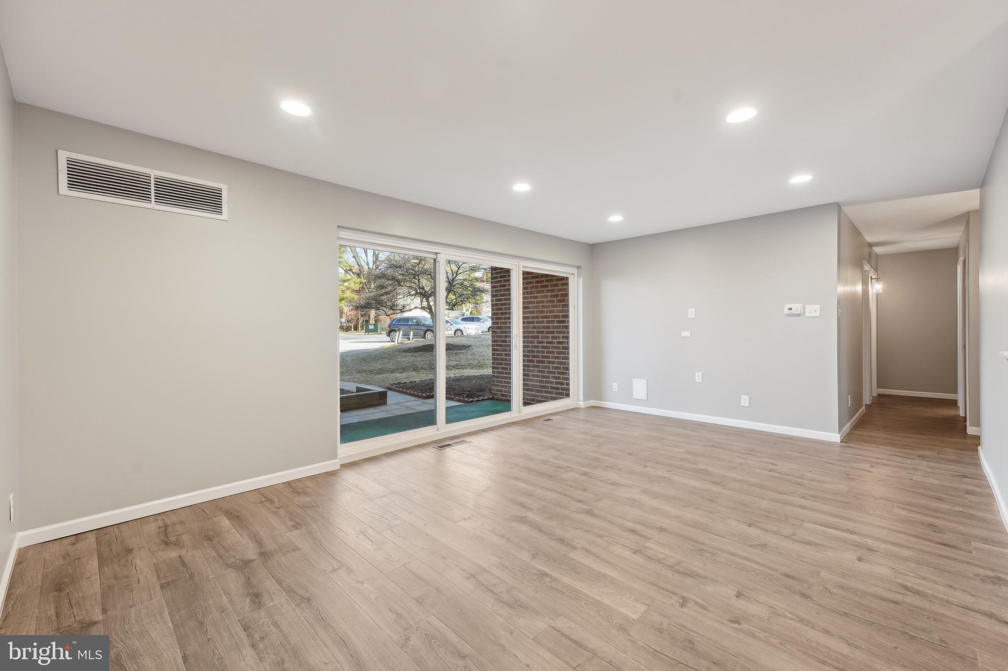 203 Drummers Lane, Unit 203 Wayne, PA 19087 - Photo 6 of 40 a view of an empty room with wooden floor and a window