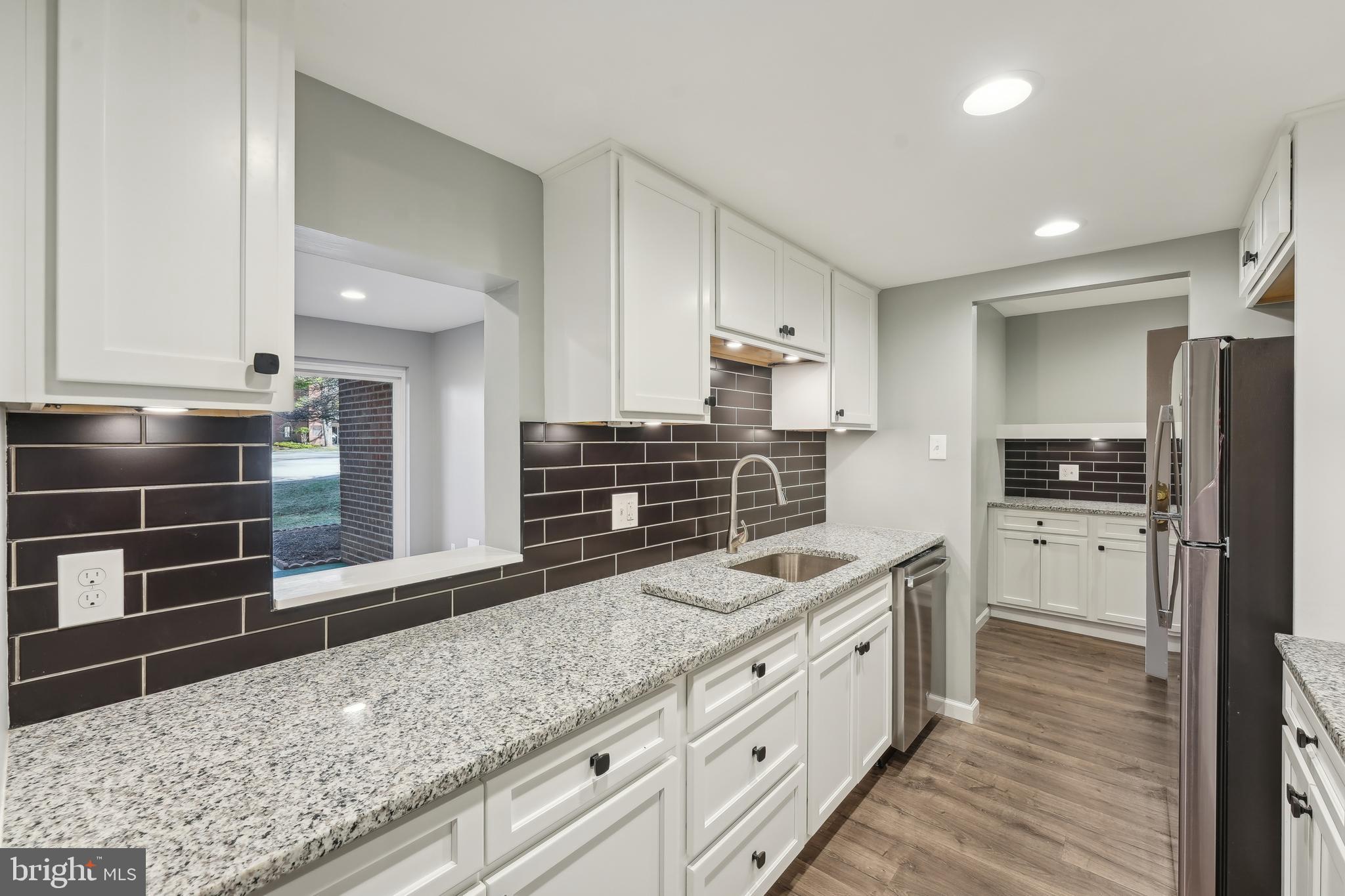 203 Drummers Lane, Unit 203 Wayne, PA 19087 - Photo 8 of 40 a kitchen with stainless steel appliances kitchen island granite countertop a refrigerator and a sink