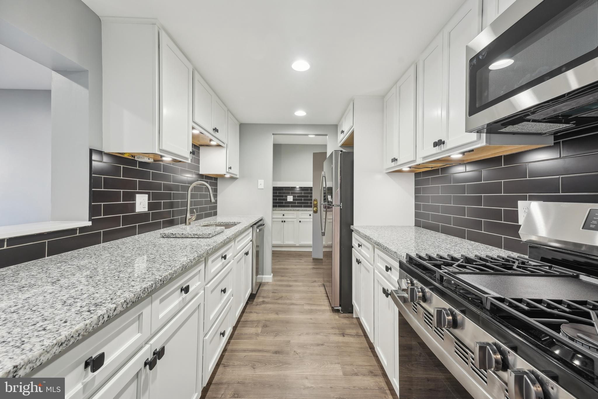 203 Drummers Lane, Unit 203 Wayne, PA 19087 - Photo 9 of 40 a large kitchen with a stove and a sink
