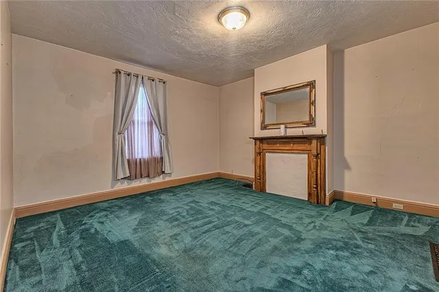 a view of an empty room with window and stairs